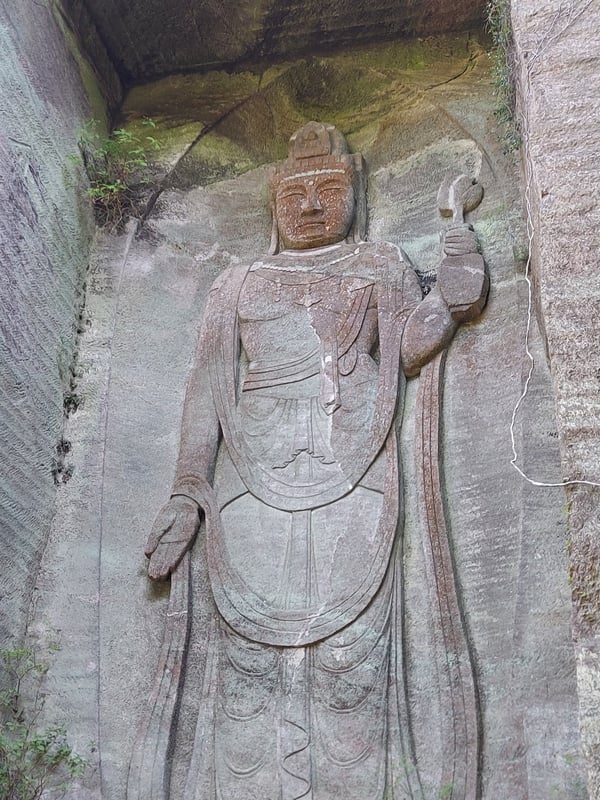 這是百丈觀音雕像，位於自然山崖上，面向外側，顯示出觀音安詳的形象。