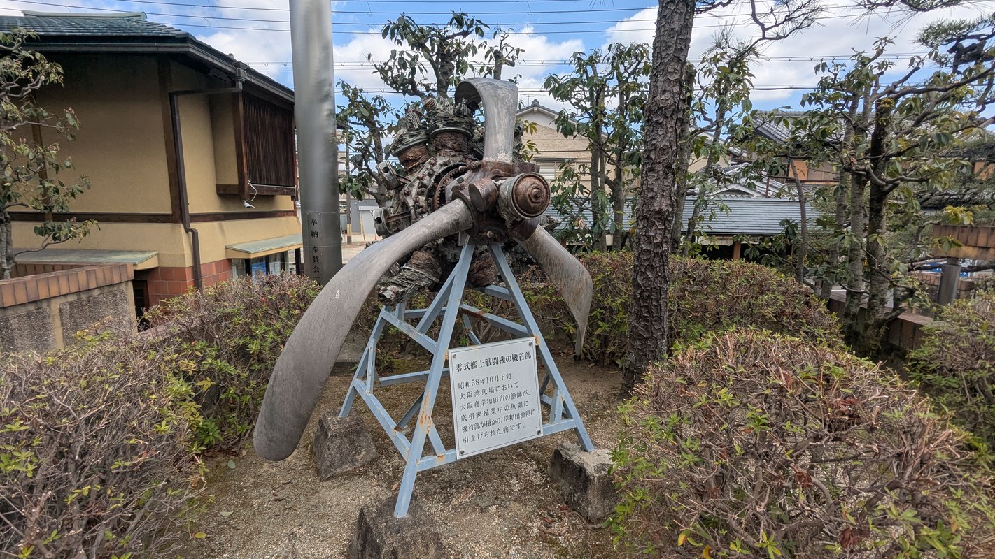 图片展示了位于日本八幡市的飞行神社的入口，背景是蓝天。