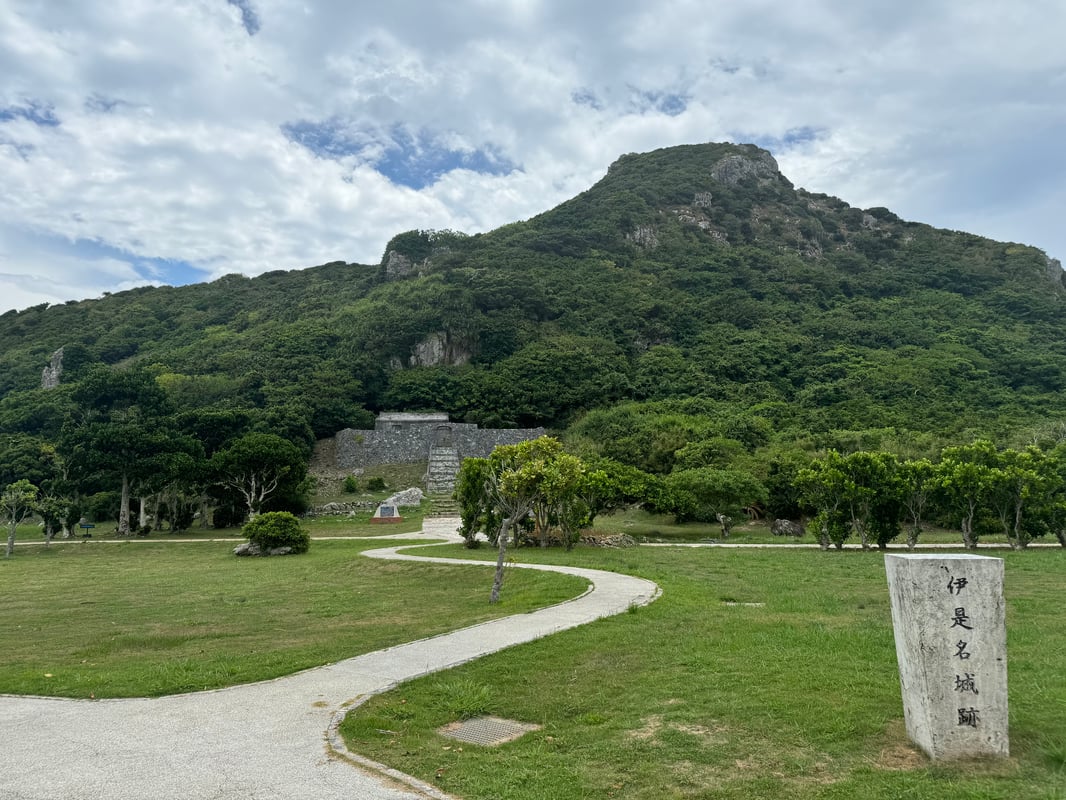 This is a photo of Izena Castle Ruins, located in Izena Village, Okinawa, Japan, showing the ancient stone wall structures.