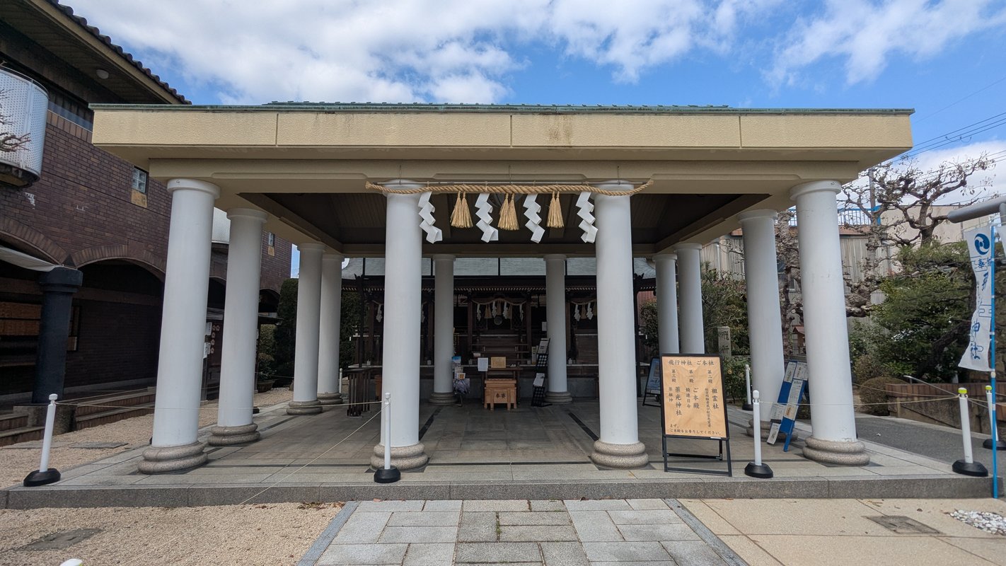 这幅图展示了八幡市的飞行神社，周围树木葱郁，环境宁静。